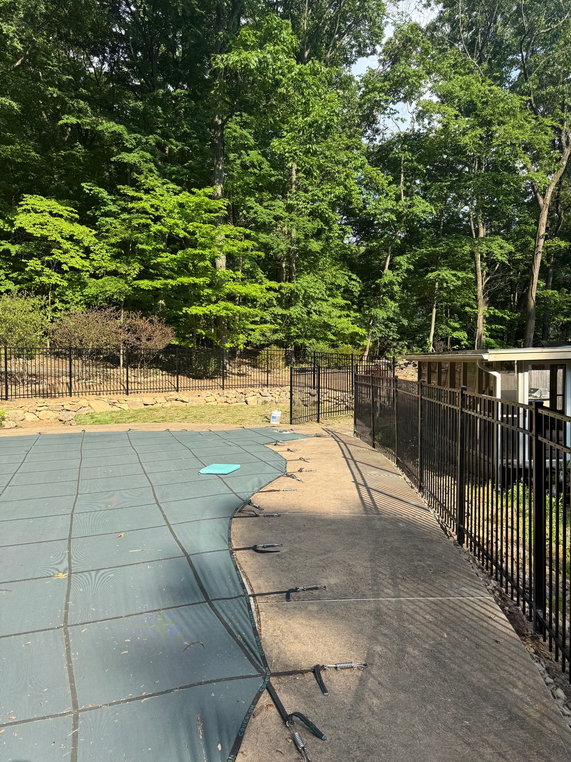Gallery photos for 240 Feet of Black Aluminum Fencing Around a Rocky Poolside Yard: Image #1