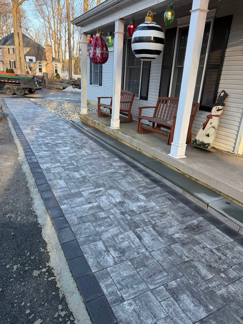 Decorative stamped concrete walkway leading to a home with holiday decorations.